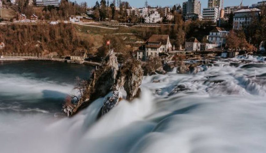 Rhine Falls with surrounding Swiss town buildings in the background